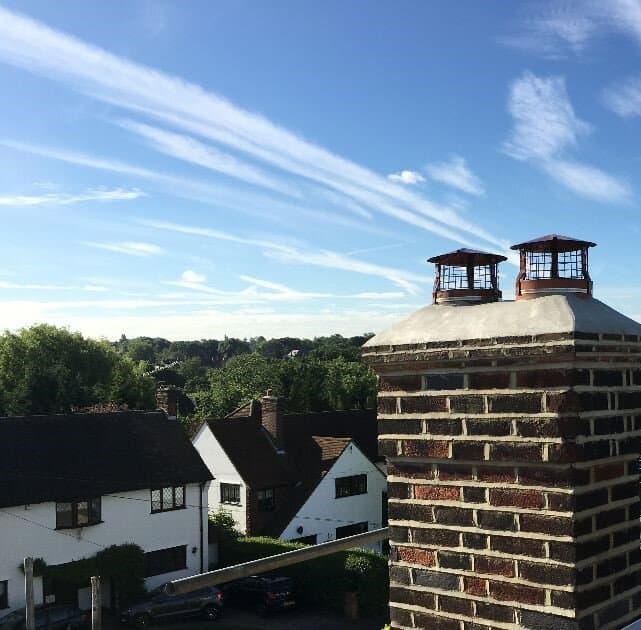 Rooftop chimney rebuild with protective caps installed in Winchmore Hill.