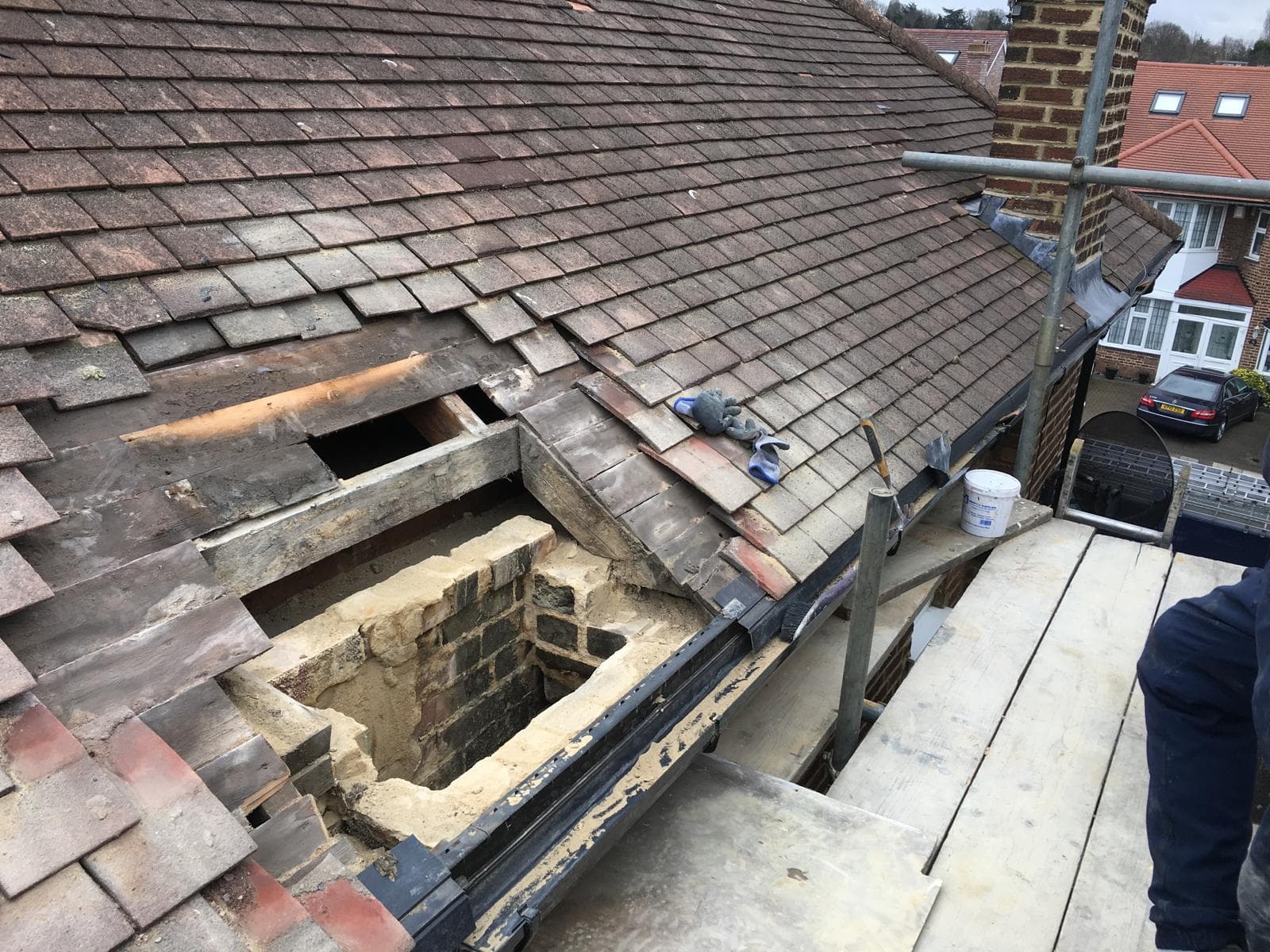 Chimney stack being removed with the roof made safe around the opening