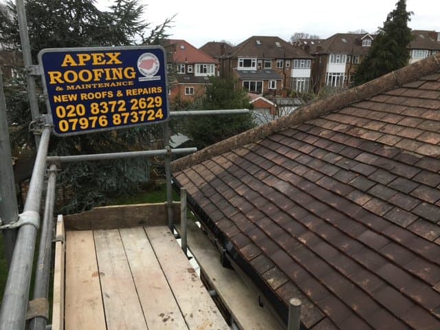 Tiled roof repair carried out from scaffold access after storm-related damage.